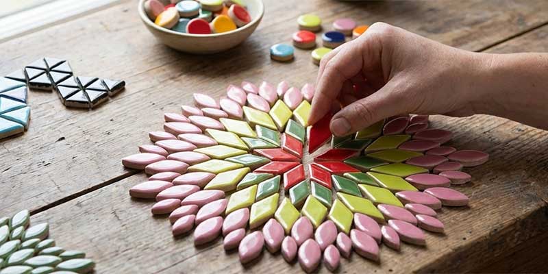 Harmonisches Mosaik aus kleinen Keramiksteinen in Grün und Rosé, angeordnet in klarer Geometrie